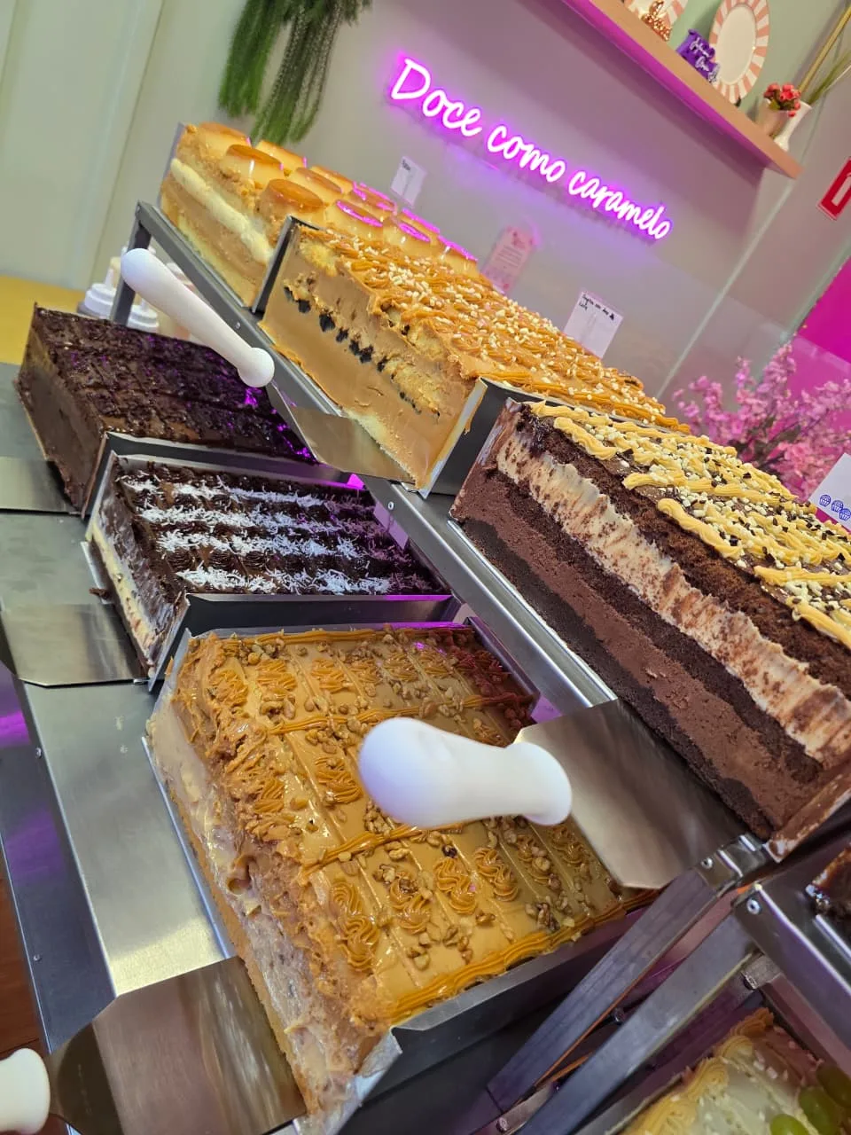 Bolos variados na estação, com o letreiro Doce como caramelo